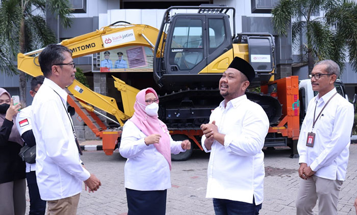 Bupati Gresik, Fandi Akhmad Yani, bersama wakilnya, Aminatun Habibah, saat menerima CSR excavator dari Bank Jatim. Foto: SYUHUD/BANGSAONLINE