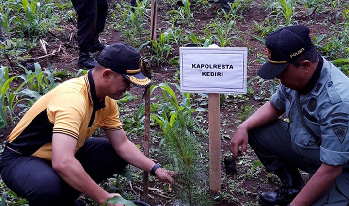 Kapolres Kediri Kota AKBP Miko Indrayana saat melakukan penanaman pohon. foto: MUJI HARJITA/ BANGSAONLINE.com