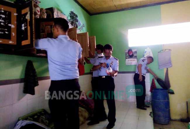 Petugas saat melakukan pemeriksaan dan penggeledahan pada napi. foto: SUWANDI/ BANGSAONLINE
