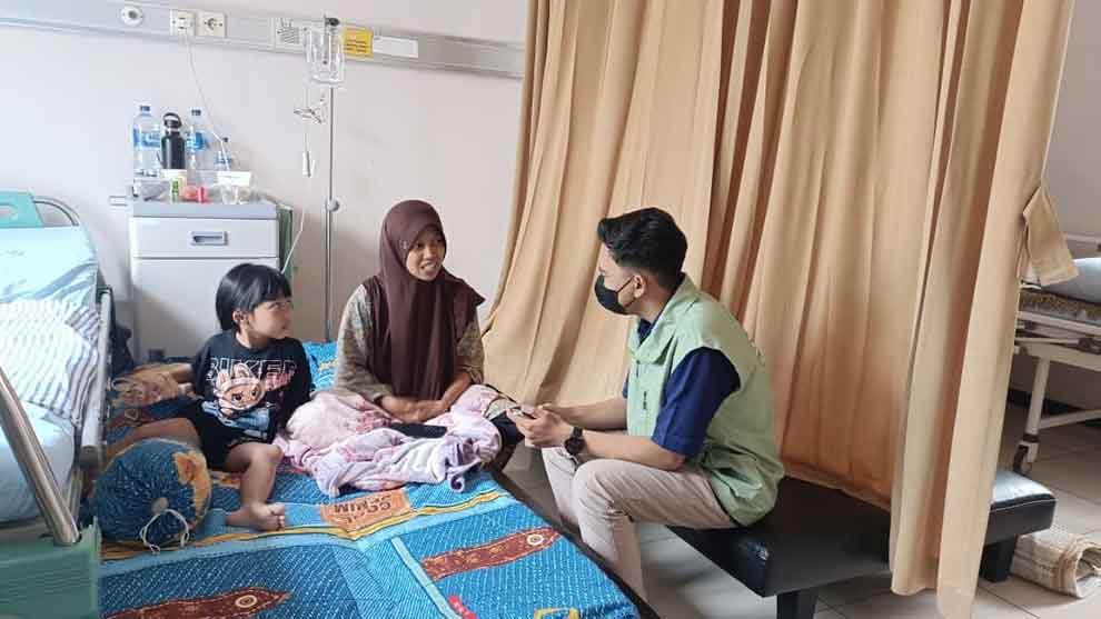 Salah satu peserta JKN dari Kediri, Furi Nihayatus Sholihah (tengah), saat berbincang dengan petugas. (Ist)