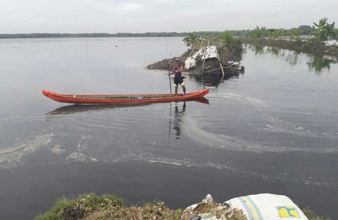 Salah satu petani sedang naik perahu di titik jebolnya tanggul kali apur ingas di Kecamatan Kanor, Bojonegoro. Petani itu belum mengikutkan sawahnya asuransi pertanian. foto: EKY NURHADI/ BANGSAONLINE