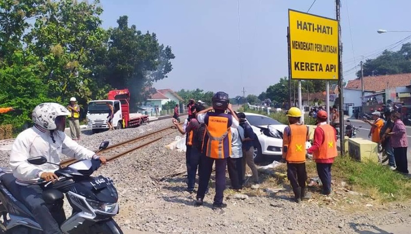 Petugas hendak mengevakuasi mobil menggunakan mobil derek.