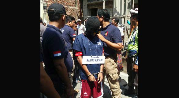 Tersangka Mas'ud saat melakukan rekronstruksi pembunuhan yang dilakukannya. (foto: eko/ BANGSAONLINE)