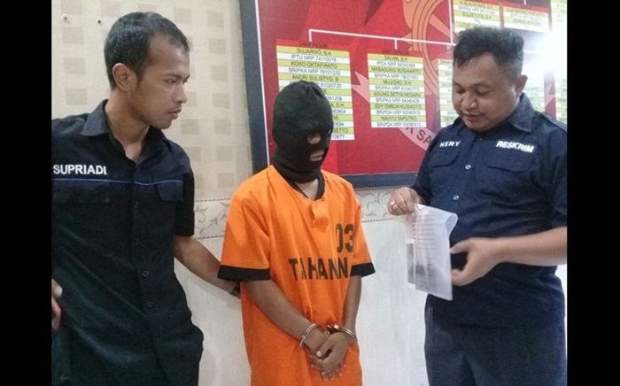Tersangka saat diapit petugas Satreskrim Polres Blitar Kota.