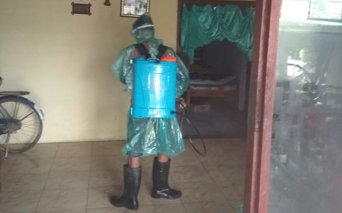 Petugas Satgas Covid-19 Desa Kambingan, saat melakukan penyemprotan di dalam rumah Ny. Mukadi. foto: ist