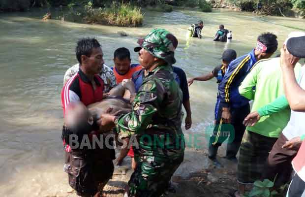 Tim SAR dibantu masyarakat saat mengevakuasi korban. foto: AHMAD/ BANGSAONLINE