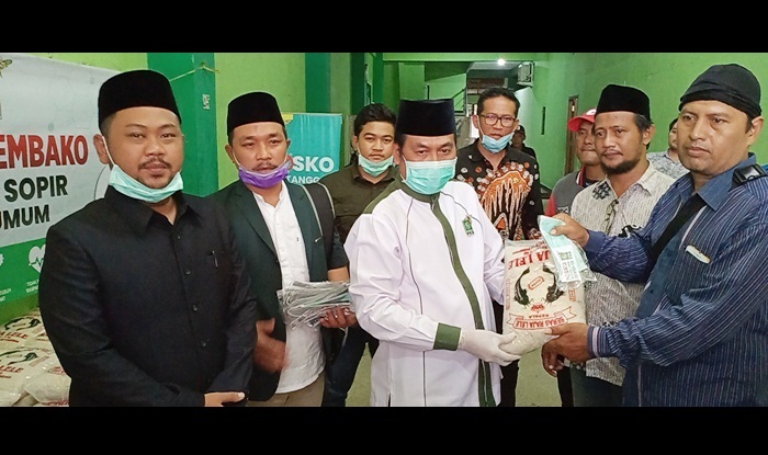Ketua DPC PKB Gresik Moh.Qosim didampingi Ketua DPRD Fandi Akhmad Yani dan Fraksi PKB DPRD saat membagikan beras kepada sopir lyn. foto: SYUHUD/ BANGSAONLINE