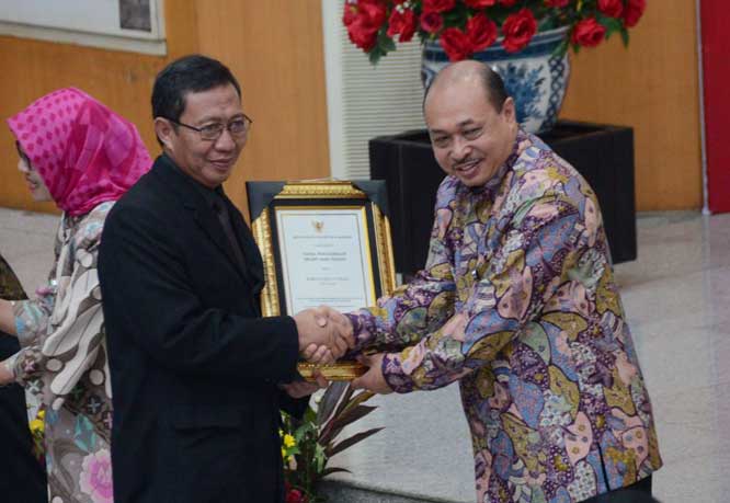Bupati Tuban saat menerima penghargaan Swasti Saba Padapa dari Staf Ahli Bidang Desentralisasi Kesehatan, dr Pattiselanno Roberth Johan.