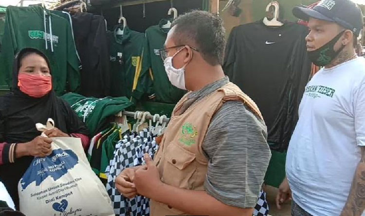 NU Care LAZISNU Jawa Timur menggandeng Bonek Surabaya membagikan sembako kepada para pedagang kaos dan atribut Persebaya di sekitar Stadion 10 Nopember, Tambaksari.