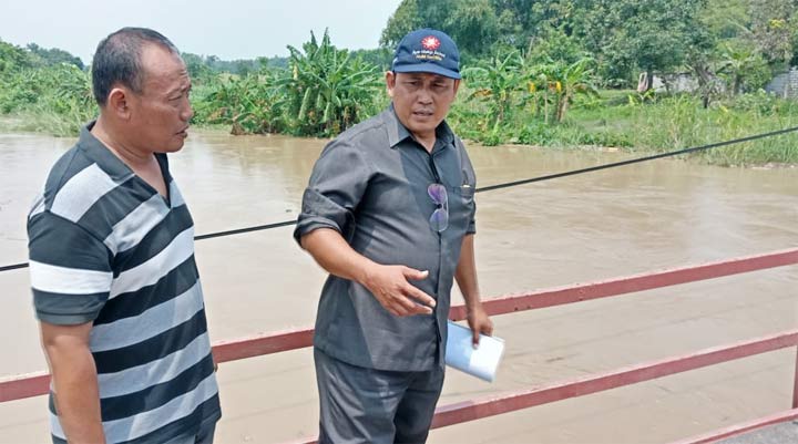 Wakil Ketua DPRD Nur Qolib ketika memantau luapan kali lamong yang merendam jalan desa.