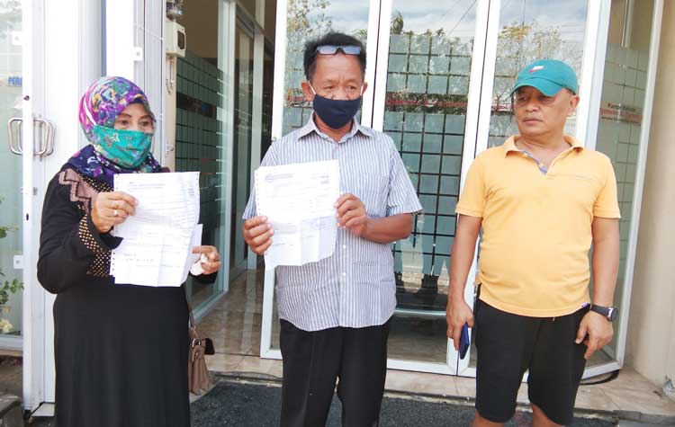 Djatmiko bersama Tole menunjukan surat bukti pembayaran dua bidang lahan tiga tahun yang lalu dari BPN Nganjuk. foto: BAMBANG/ BANGSAONLINE