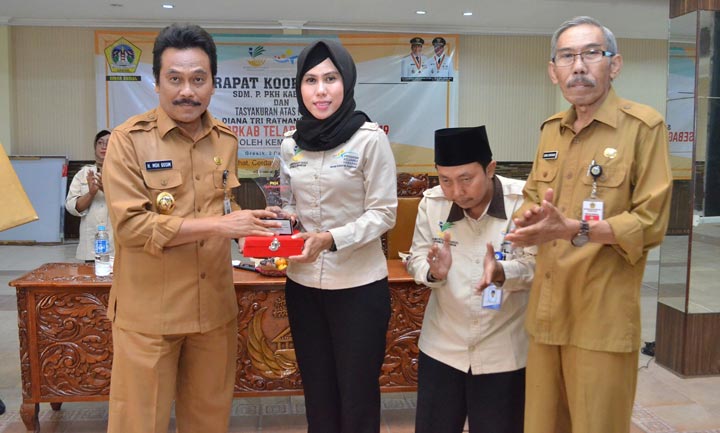 Wabup Qosim menyerahkan penghargaan secara simbolis kepada Korkab PKH Gresik Diana Tri Ratna Ningtyas disaksikan Kepala Dinsos Sentot Supriyohadi. foto: ist.