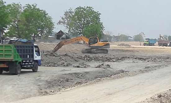 Aktivitas alat berat mengeruk waduk di Desa Metatu, Benjeng. foto: syuhud/BANGSAONLINE