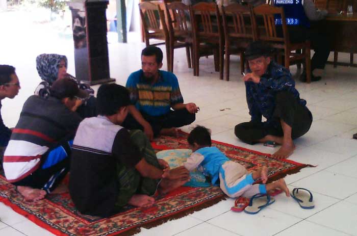 Suhud bersama keluarga dan pendukungnya sudah dua hari ini 'nginap' di Balai Desa Sumurber. foto: SYUHUD/ BANGSAONLINE