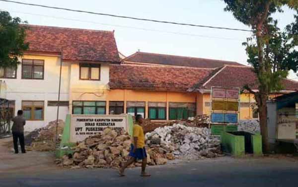 Salah seorang warga sedang melintas di depan Kantor UPT Puskesmas Ganding, yang saat ini masih direnovasi. foto: faisal/BANGSAONLINE