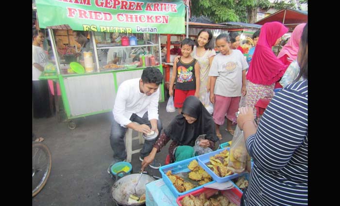 Emil saat mengcoba membuat martabak mie Madura di pasar kaget takjil Karang Menjangan, Surabaya.