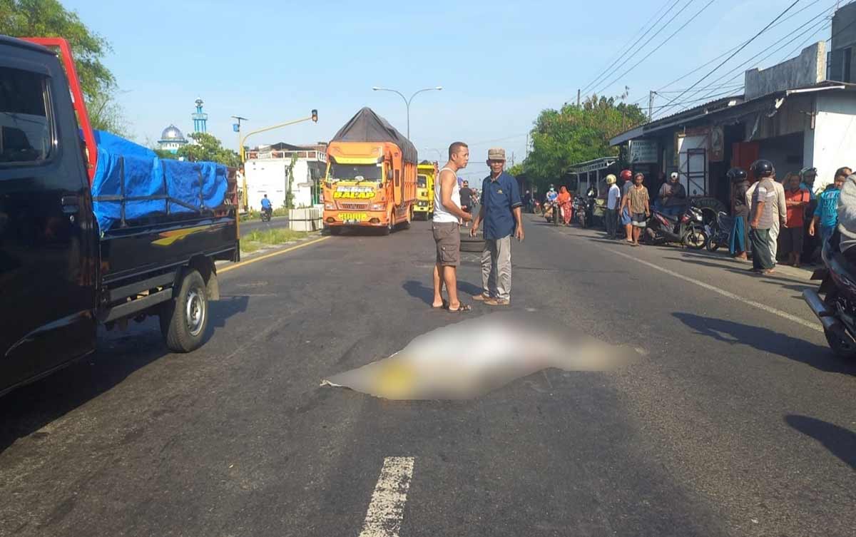 Warga saat mengevakuasi korban kecelakaan yang terlindas truk di Jombang.