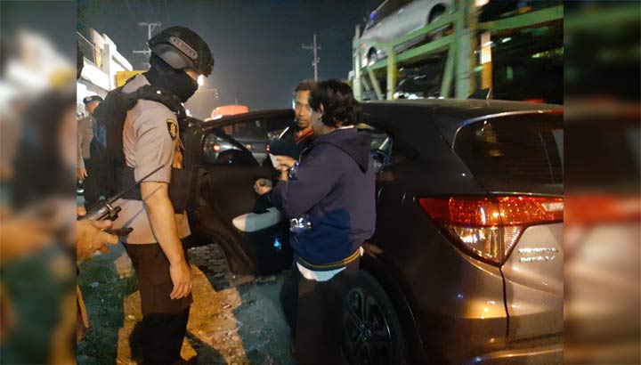 Kapolres Gresik AKBP Wahyu S. Bintoro memeriksa kendaraan roda empat yang melintas di Jalan Raya Kedamean. foto: SYUHUD/ BANGSAONLINE