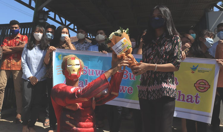 Iron Man Kampung Tangguh RW 04 saat memberi bunga kepada seorang mahasiswi demi memberikan support dan selamat atas kesembuhannya. (foto: ist).