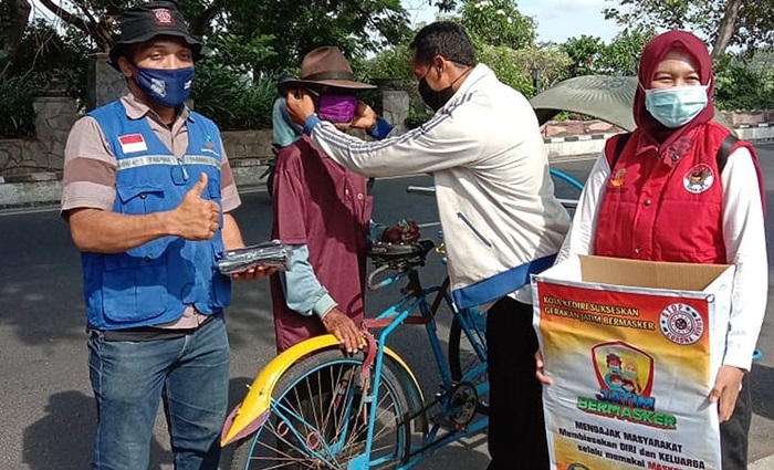 Petugas saat memakaikan masker kepada warga. foto: ist.