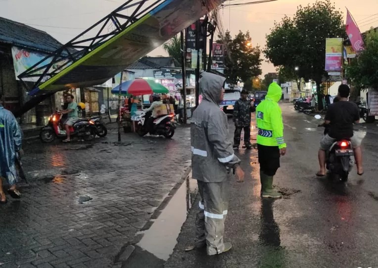 Petugas saat mengatur lalu lintas di depan lokasi rubuhnya papan reklame