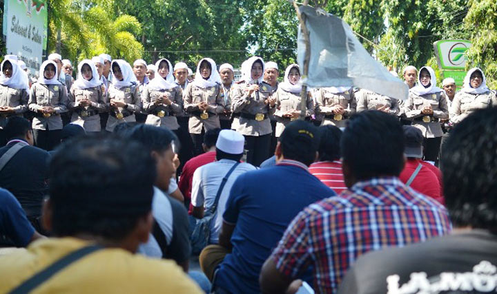 Tim Asmaul Husna, para polisi berkopyah dan polwan berhijab sedang berupaya meredam aksi.