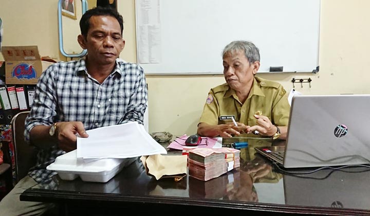 Mahmudi (kiri) anggota Komisi A saat mengambalikan uang saku kunker sebesar Rp 38 juta kepada Ridwan Kasubag Persidangan dan Risalah Sekretaris Dewan Kabupaten Bangkalan.