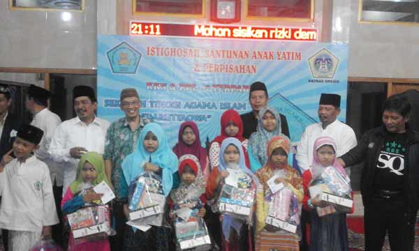 Dewan pendiri RGS SQ, H Moh Khozin, didampingi Ketua Harian, Khumaidi Ma'un ketika santuni anak yatim piatu. (syuhud/BANGSAONLINE)