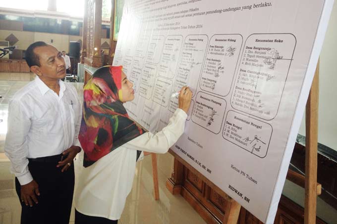 Satu per satu cakades membubuhkan tanda tangan di atas naskah raksasa deklarasi ikrar damai. foto: SUWANDI/ BANGSAONLINE