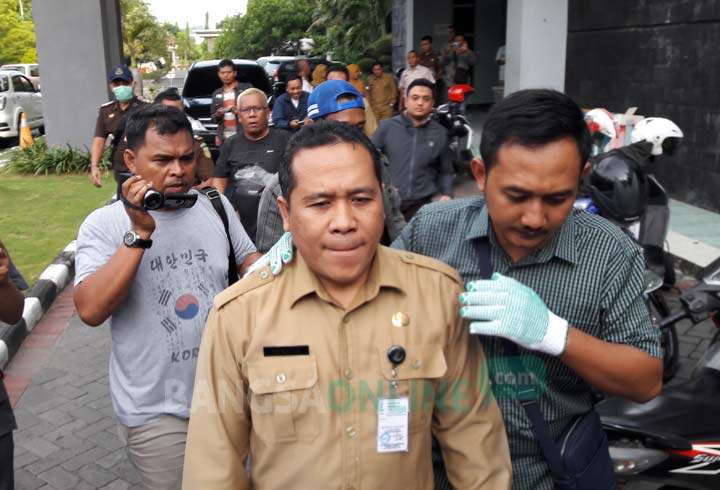 Sekretaris BPPKAD Gresik Muktar saat digiring petugas ke kantor Kejaksaan usai penggeledahan. foto: SYUHUD/ BANGSAONLINE