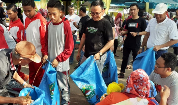 Bupati Pamekasan Baddrut Tamam (kaos hitam berkaca mata) saat memungut sampah di area Car Free Day (CFD) Taman Monumen Arek Lancor.