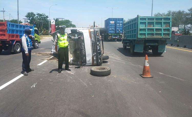 Truk boks nopol L 9085 BH yang terguling di Jalan Tol Kilometer 753.800. (foto: ist).