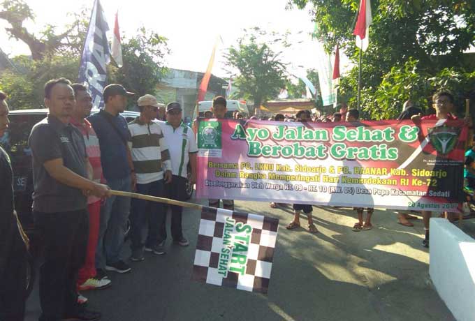 SIMBOLIS: Ketua DPRD Sidoarjo H Sullamul Hadi Nurmawan membuka Jalan Sehat dan Pengobatan Gratis di Desa Pepe RW 05, Kecamatan Sedati, Minggu (20/8). foto: mustain/ BANGSAONLINE.com