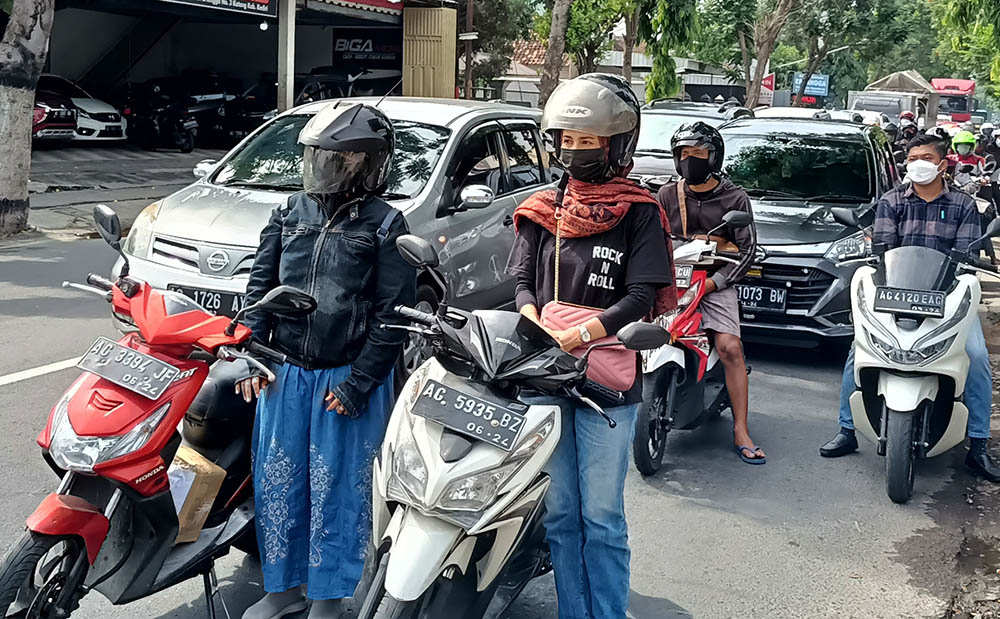 Dua ibu-ibu turun dari sepeda motornya untuk bersama-sama mengheningkan cipta di Simpang 3 Jalan Soekarno Hatta, Katang. foto: MUJI HARJITA/ BANGSAONLINE