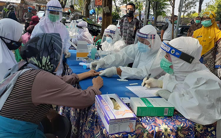 Petugas kesehatan saat melakukan rapid test kepada pengunjung Pasar Legi Mojosari.