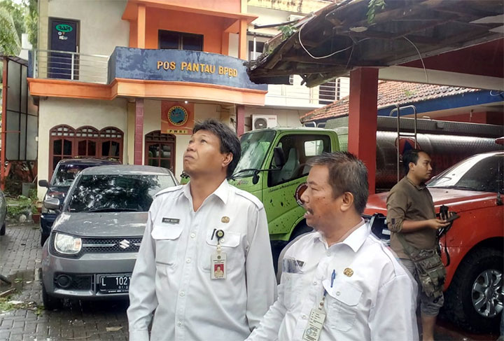 Kepala DLH Gresik Moh. Najikh saat meninjau pohon tumbang yang menimpa kantor BPBD. foto: SYUHUD/ BANGSAONLINE