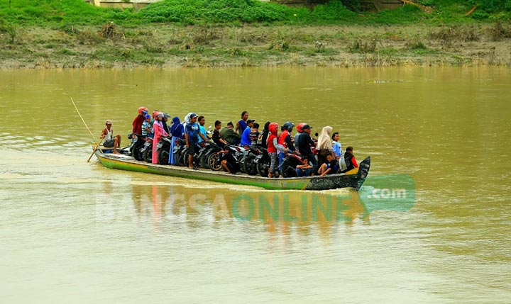 BAHAYA: Perahu tambang di Dusun Mruwut, Desa Semambung, Kecamatan Kanor tampak dipenuhi penumpang yang menyeberang untuk liburan. foto: EKY NURHADI/ BANGSAONLINE